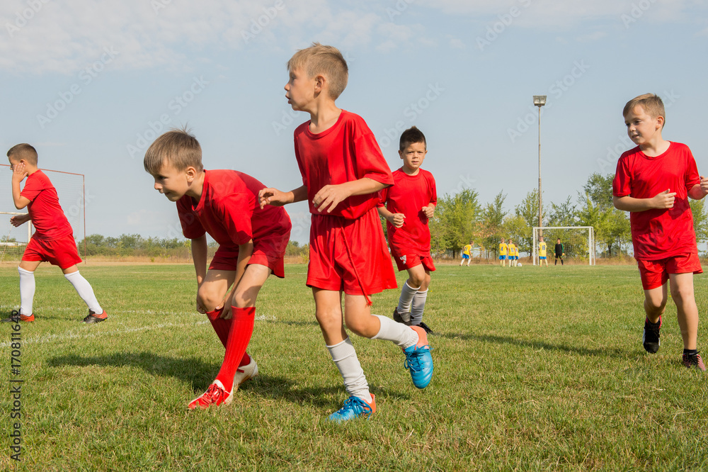 Obraz premium Kids soccer football - children players exercising before match on soccer field