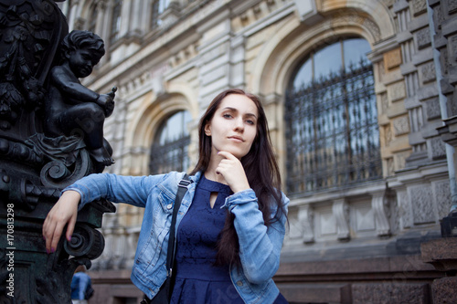 Beautiful young brunette with a backpack in the city, portrait