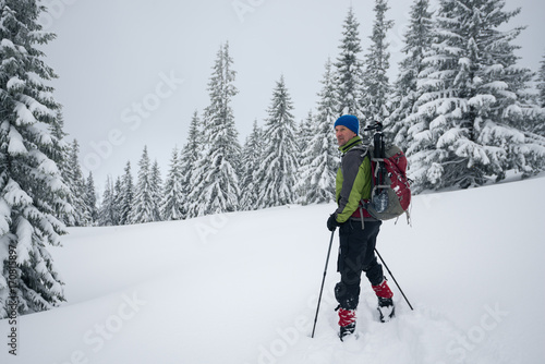 Smiling traveler is standing in a deep snow