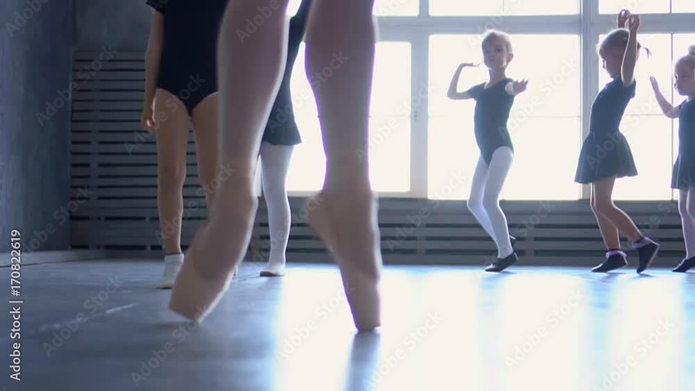 Group of ballet dancers jumping in the air. Young ballerinas jumping in training. School of ballet. Feet closeup Group of ballet dancers jumping in the air. Young ballerinas jumping in training. School of ballet. Feet closeup
