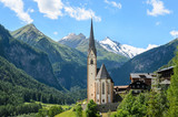 Heiligenblut, Carinthia, Austria, A scenic landscape photo of the Austrian municipality of Heiligenblut with St. Vincent Church in front of the Hohe Tauern mountains.