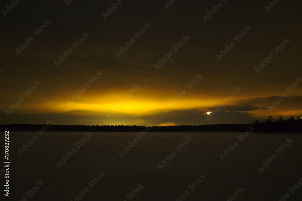 Light pollution in wilderness. Yellow glow over lake and forest.