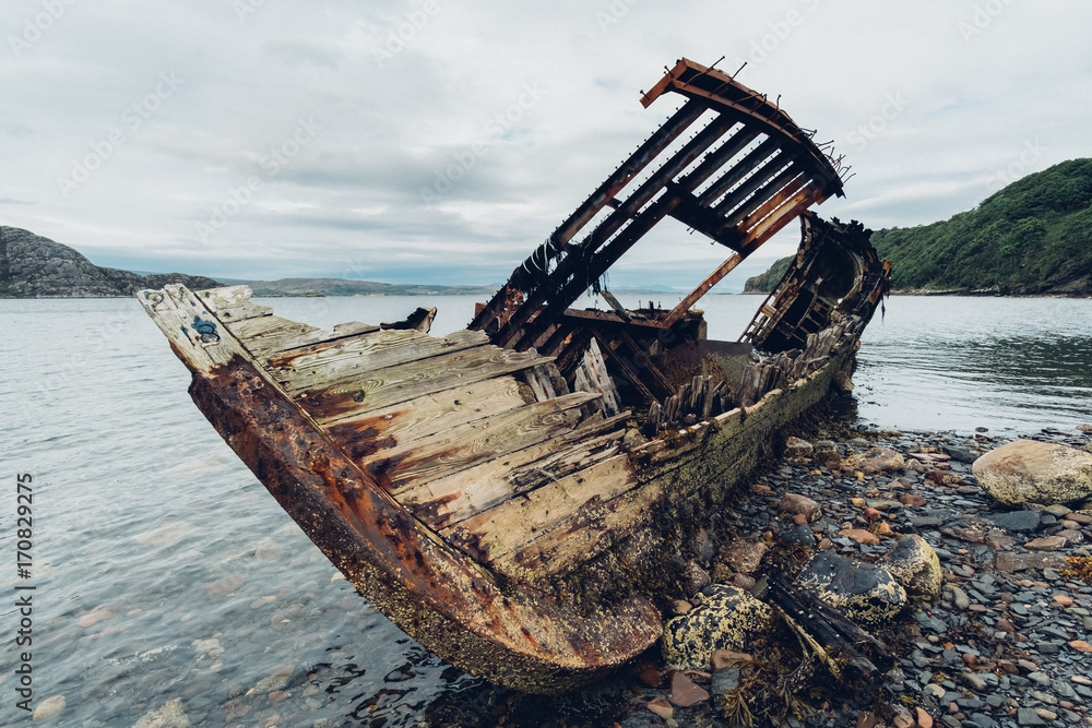 Old wooden shipwreck on a beach on the North-West of Scotland. Scottish Highland, UK