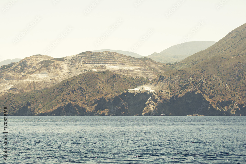 sea, mountains and marble quarry landscape, view from sailboat