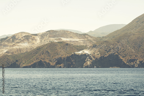 sea, mountains and marble quarry landscape, view from sailboat