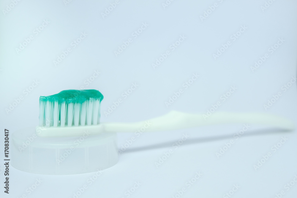toothbrush on the white background with the green toothpaste toothbrush on the white background with the green toothpaste