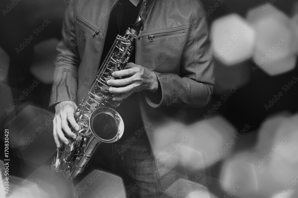 Obraz premium Saksofonista jazzowy w wykonaniu na scenie. Dodano filtr kolorów i sześciokątny efekt bokeh.