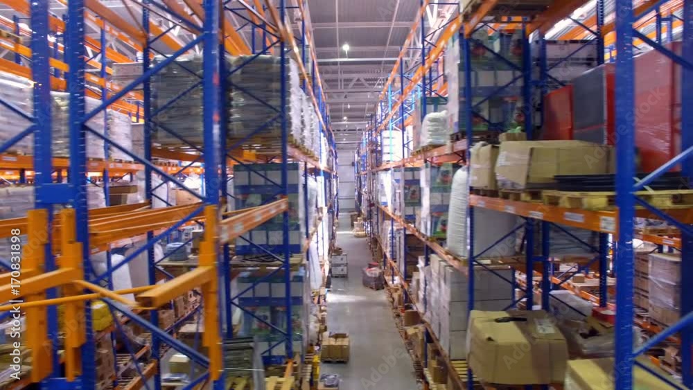 Warehouse interior. Camera is moving along shelfs. Aerial. 4K. Warehouse interior. Camera is moving along shelfs. Aerial. 4K.