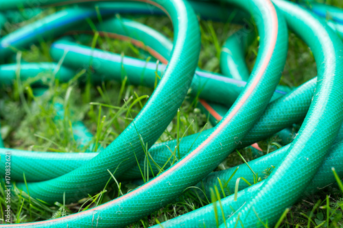 A green and orange hose for watering the garden