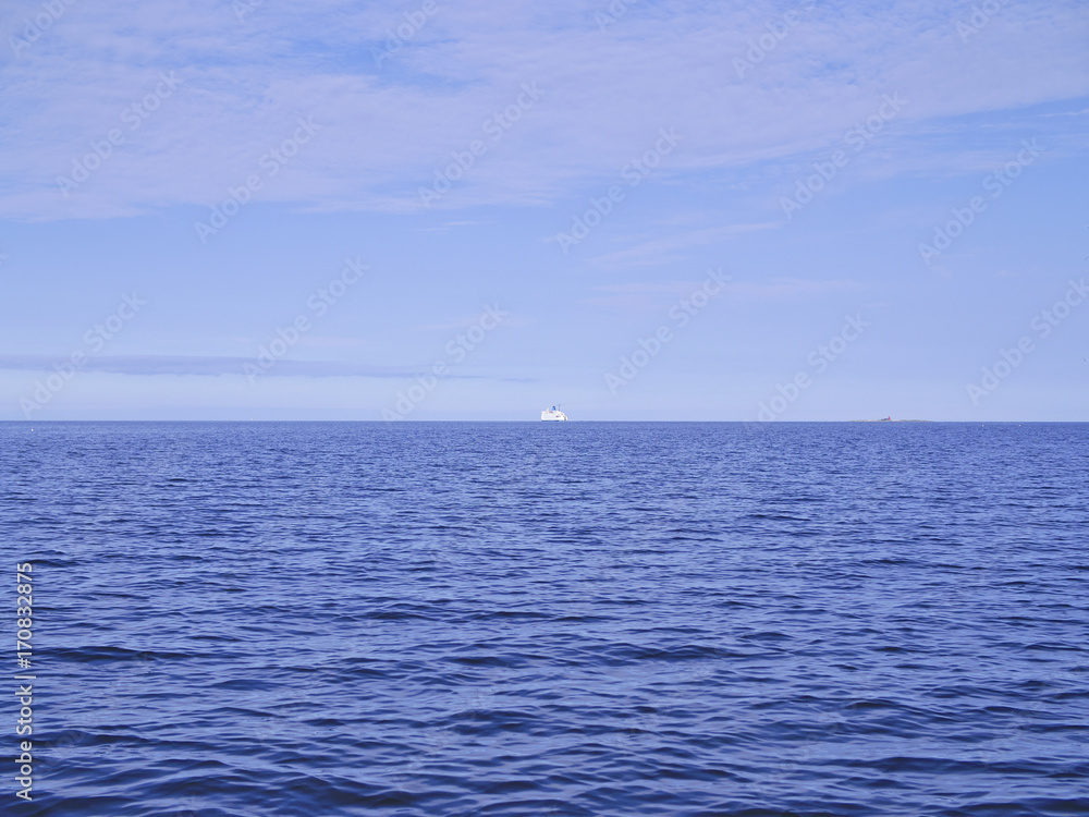 White ship sailing to the horizon on calm blue sea. White ship sailing to the horizon on calm blue sea.