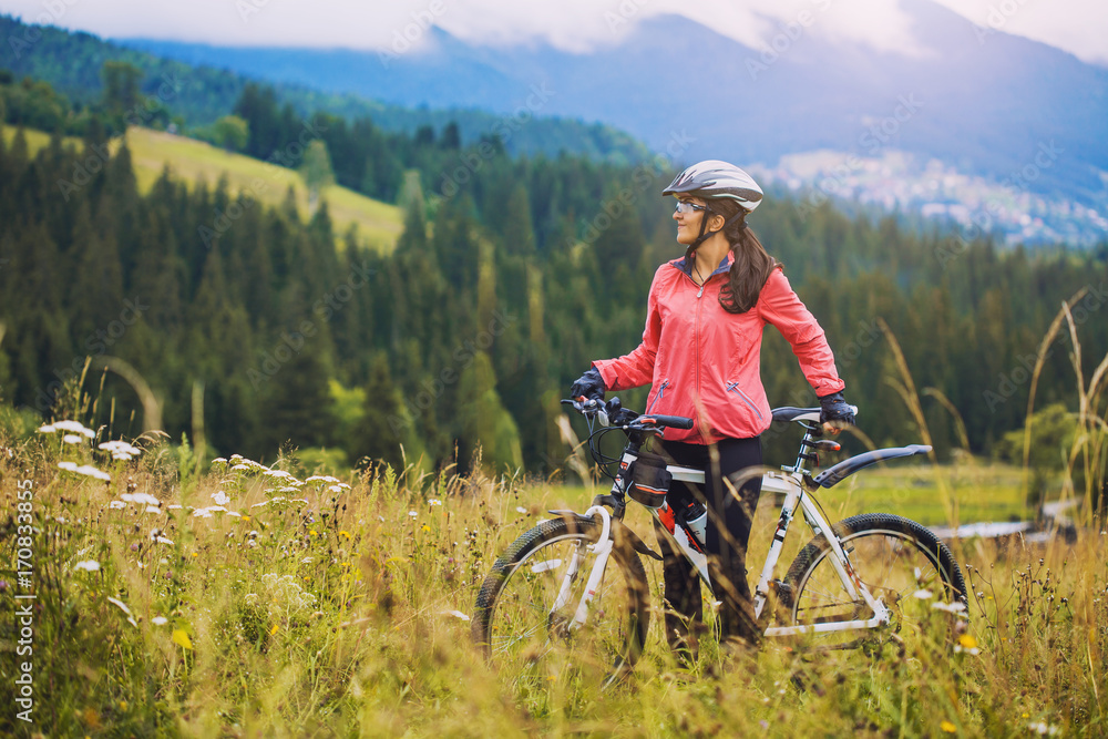 Obraz premium young woman riding a bicycle on the high plateau