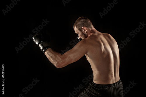 The young man kickboxing on black © master1305