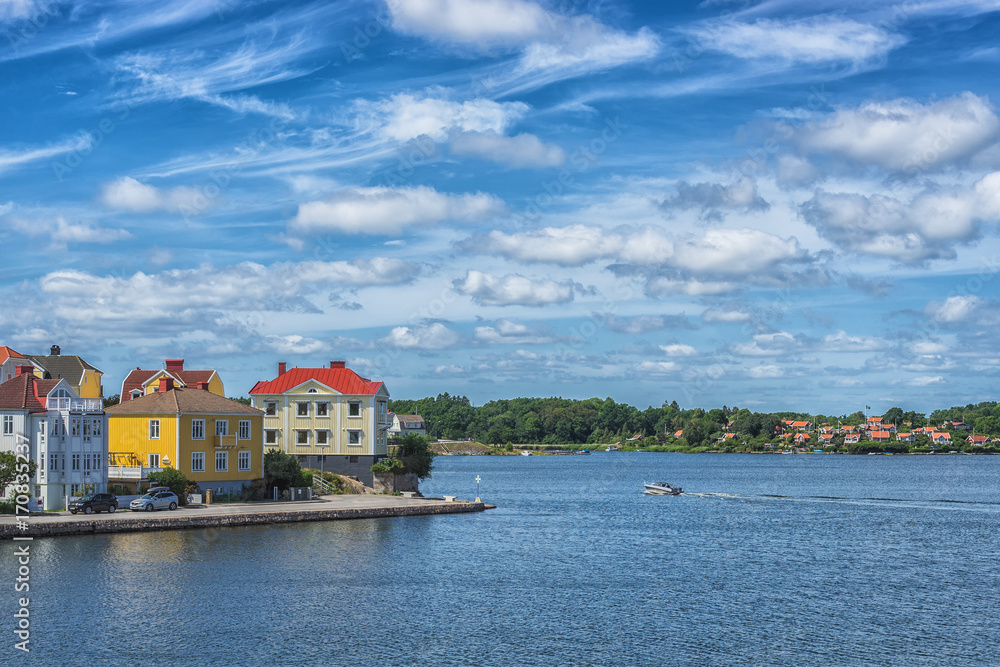 Obraz premium KARLSKRONA, SWEDEN - 2017 July. Typical red Swedish wooden houses with natiaonal flag in the city of Karlskrona
