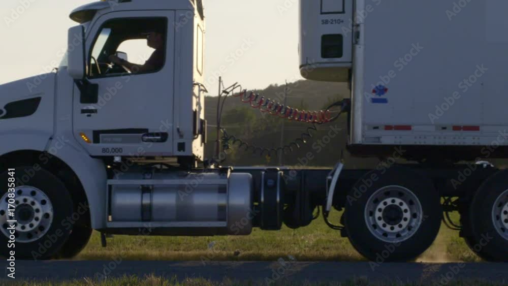 Driver starts vehicle engine and pulls away, kicking up dust from backlit country road. Side view, slow motion 4K recorded at 60fps Driver starts vehicle engine and pulls away, kicking up dust from backlit country road. Side view, slow motion 4K recorded at 60fps