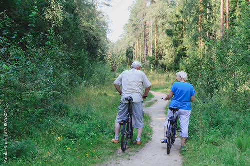 active senior couple riding bikes in nature