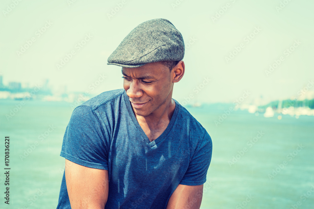 Young black man relaxing by lake