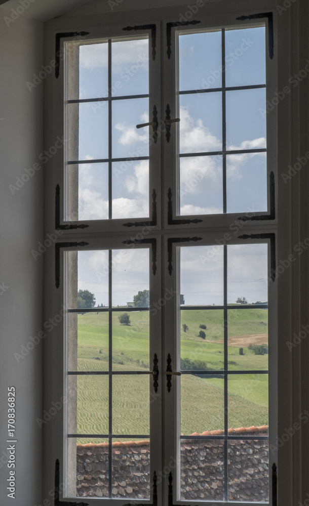 Fototapeta premium Ancient glass window with panoramic view over green hills