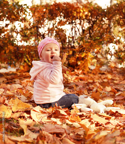 happy little child  baby girl laughing and playing in the autumn on the nature walk outdoors