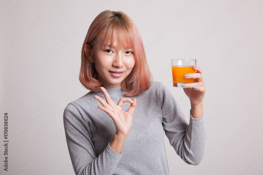 Young Asian woman show OK drink orange juice. Young Asian woman show OK drink orange juice.