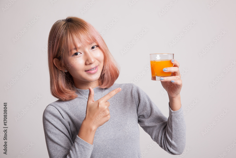 Young Asian woman point to orange juice. Young Asian woman point to orange juice.