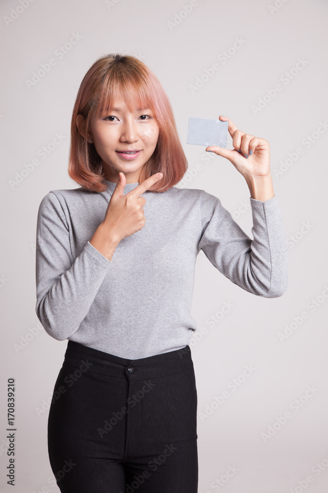 Young Asian woman point to a blank card. Young Asian woman point to a blank card.