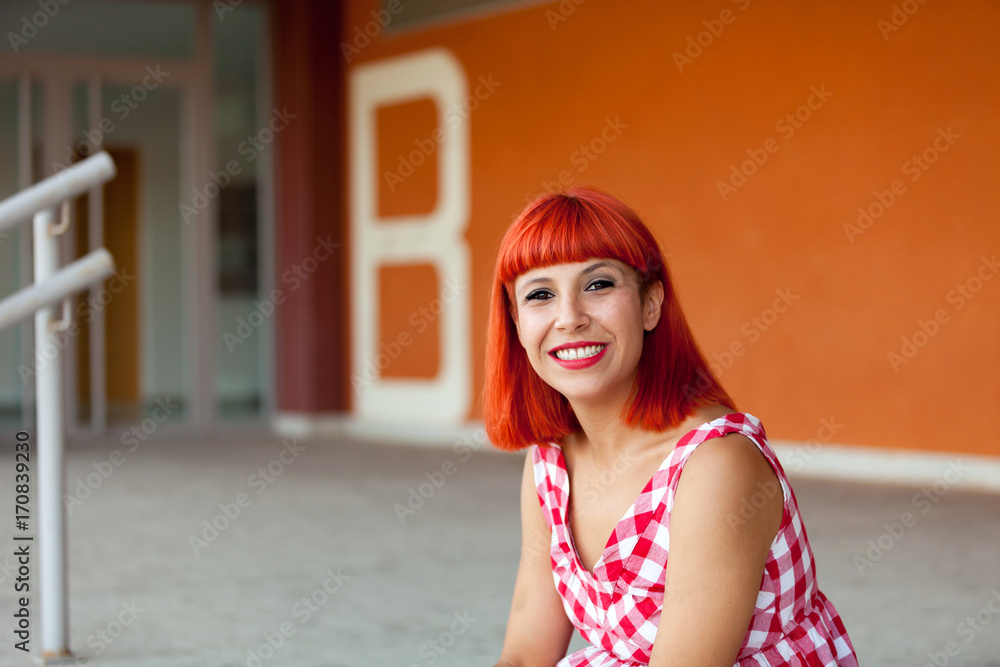 Red haired woman looking at camera in the stree Red haired woman looking at camera in the stree