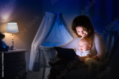 Mother reading a book to little baby