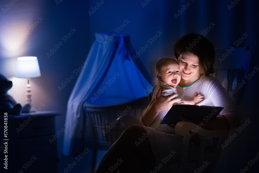 Naklejka premium Mother reading a book to little baby