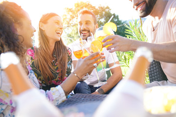 Group of friends cheering with summer cocktails