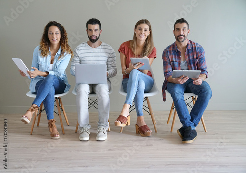 Young people connected on internet in waiting room photo