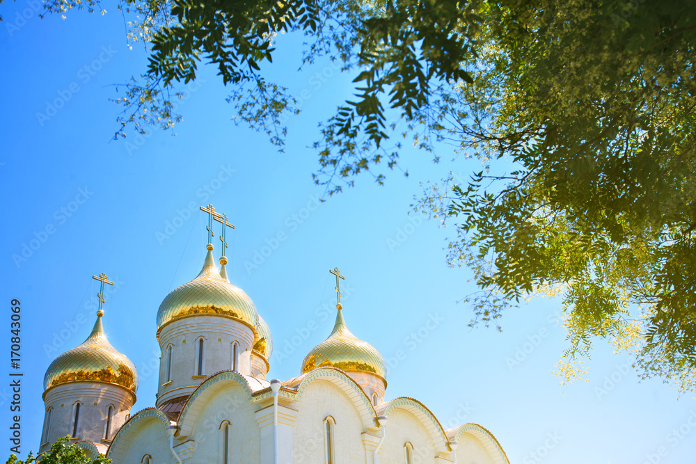 Golden domes of the Orthodox church against the blue sky.
