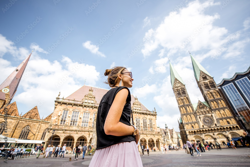 Fototapeta premium Young woman tourist enjoying great view on the city hall building and church in the centre of Bremen, Hamburg