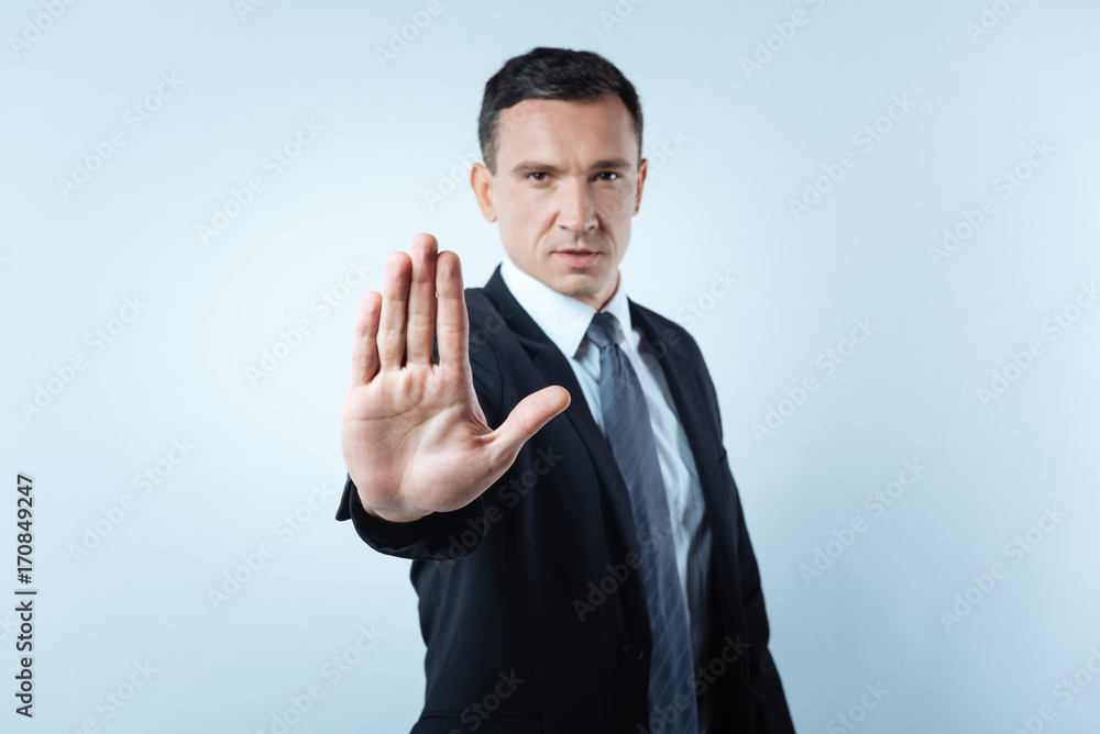 Serious handsome man showing his palm Serious handsome man showing his palm
