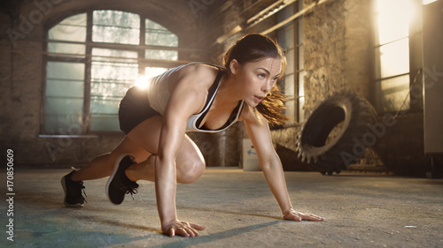 Sportowa piękna kobieta robi bieganie desce jako część jej krzyża sprawności, rutynowego treningu w siłowni.