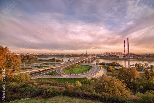 panorama of city center Kemerovo on river Tom with two bridges under colorful cloudy sky Siberia, Russia