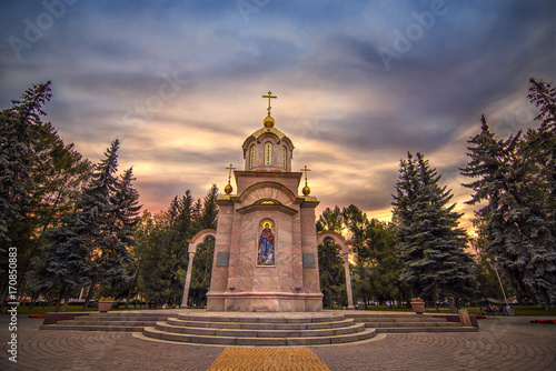Obraz na płótnie Sunset view of small Chapel surrounded by trees with colorful sky in Kemerovo downtown Siberia? Russia w salonie
