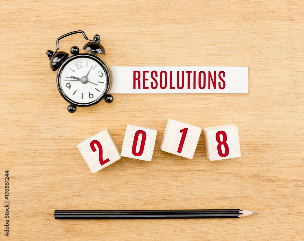 Resolutions 2018 new year red on wood cube with pencil and clock top view on wood table,New year business concept. Resolutions 2018 new year red on wood cube with pencil and clock top view on wood table,New year business concept.
