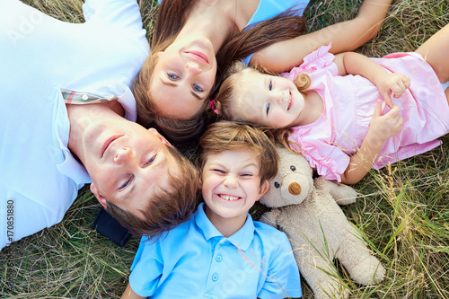 Фотография Happy family lying on grass close-up view from above in nature .