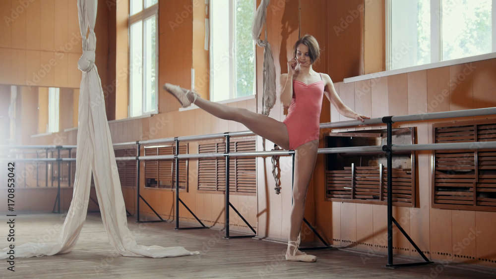 Girl ballerina use smatphone in a dancing room Girl ballerina use smatphone in a dancing room