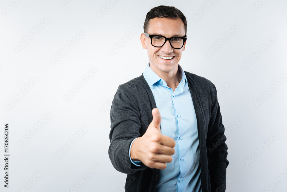 Joyful smart man showing thumbs up gesture Joyful smart man showing thumbs up gesture