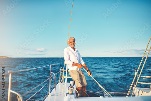 Smiling mature man out for a sail on his boat © Flamingo Images