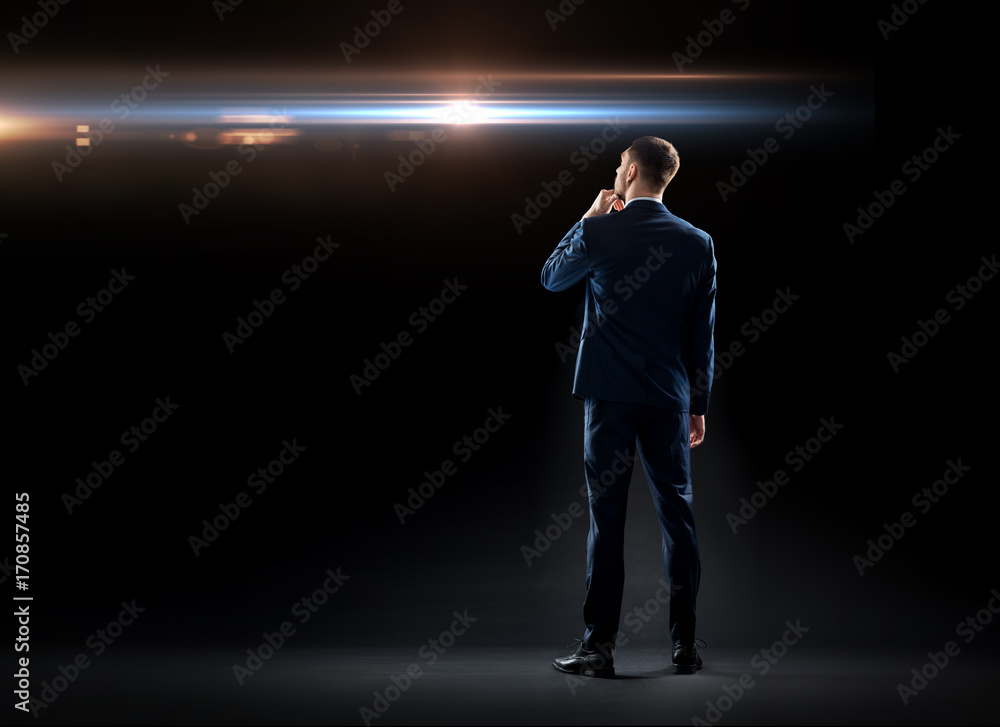 Fototapeta premium businessman over black looking at laser light