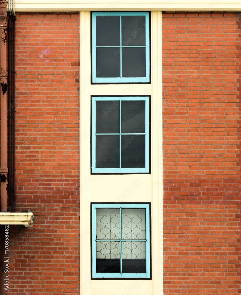 antique blue wood window at brown brick building antique blue wood window at brown brick building