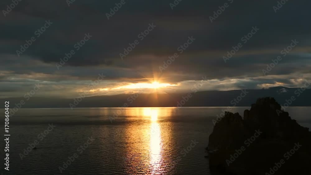 Beautiful colorful sunset at the Lake Baikal with dramatic clouds and sun shining. Beautiful colorful sunset at the Lake Baikal with dramatic clouds and sun shining.