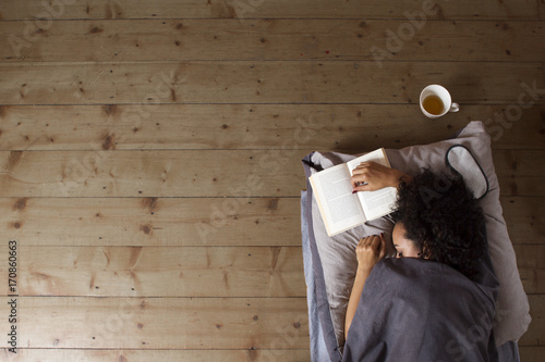 Junge Frau mit Buch im Bett