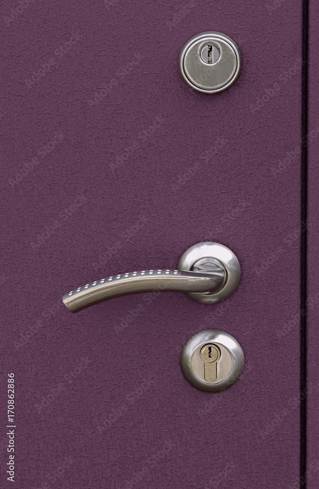 The surface of a metal door with lock and handle The surface of a metal door with lock and handle