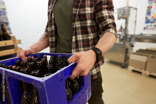 man with bottles in box at craft beer brewery