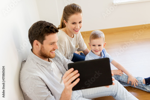 happy family with tablet pc moving to new home