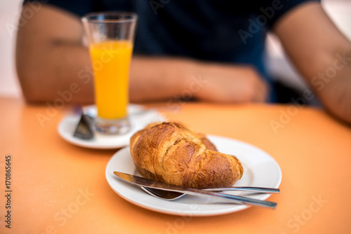 freshly made croissant on the plate and glass of orange juice,traditional breakfast photo