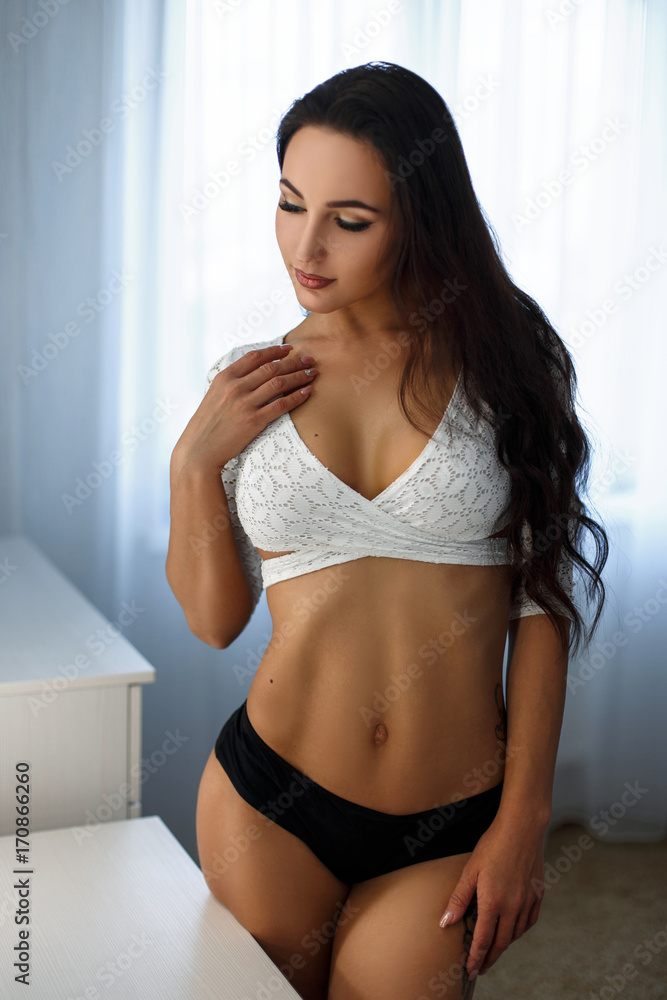 Beautiful young girl with a big boobs in a sexy white bra and black panties  in the bedroom Stock Photo | Adobe Stock